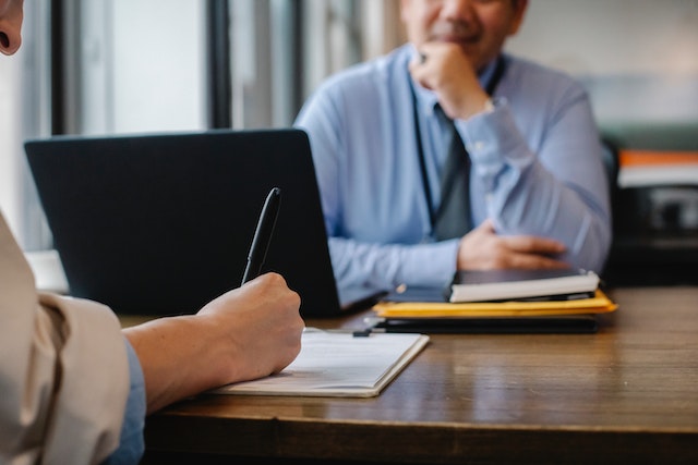 a tenant signing a contract as a landlord in a blue shirt watches